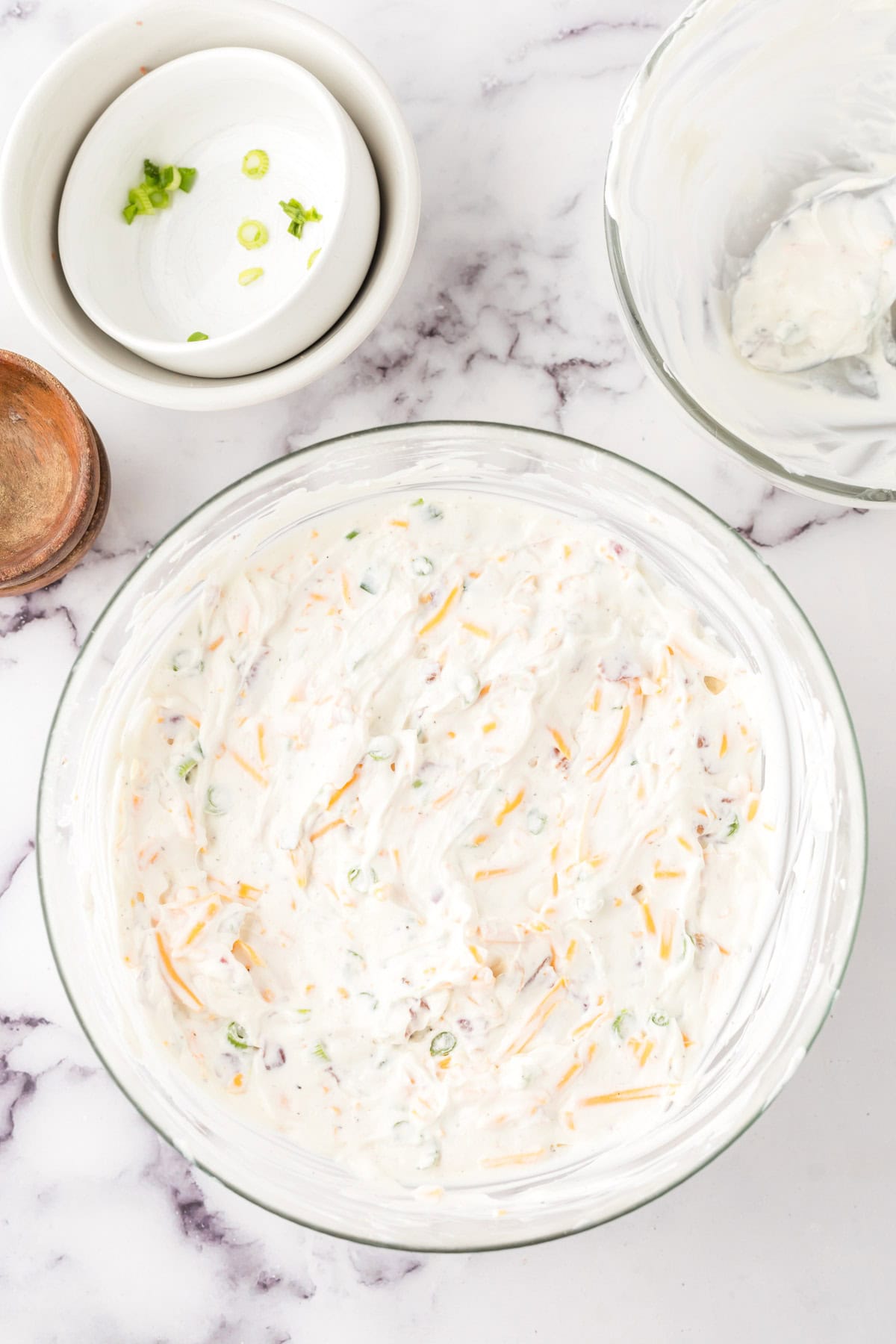 loaded baked potato dip in a clear mixing bowl.