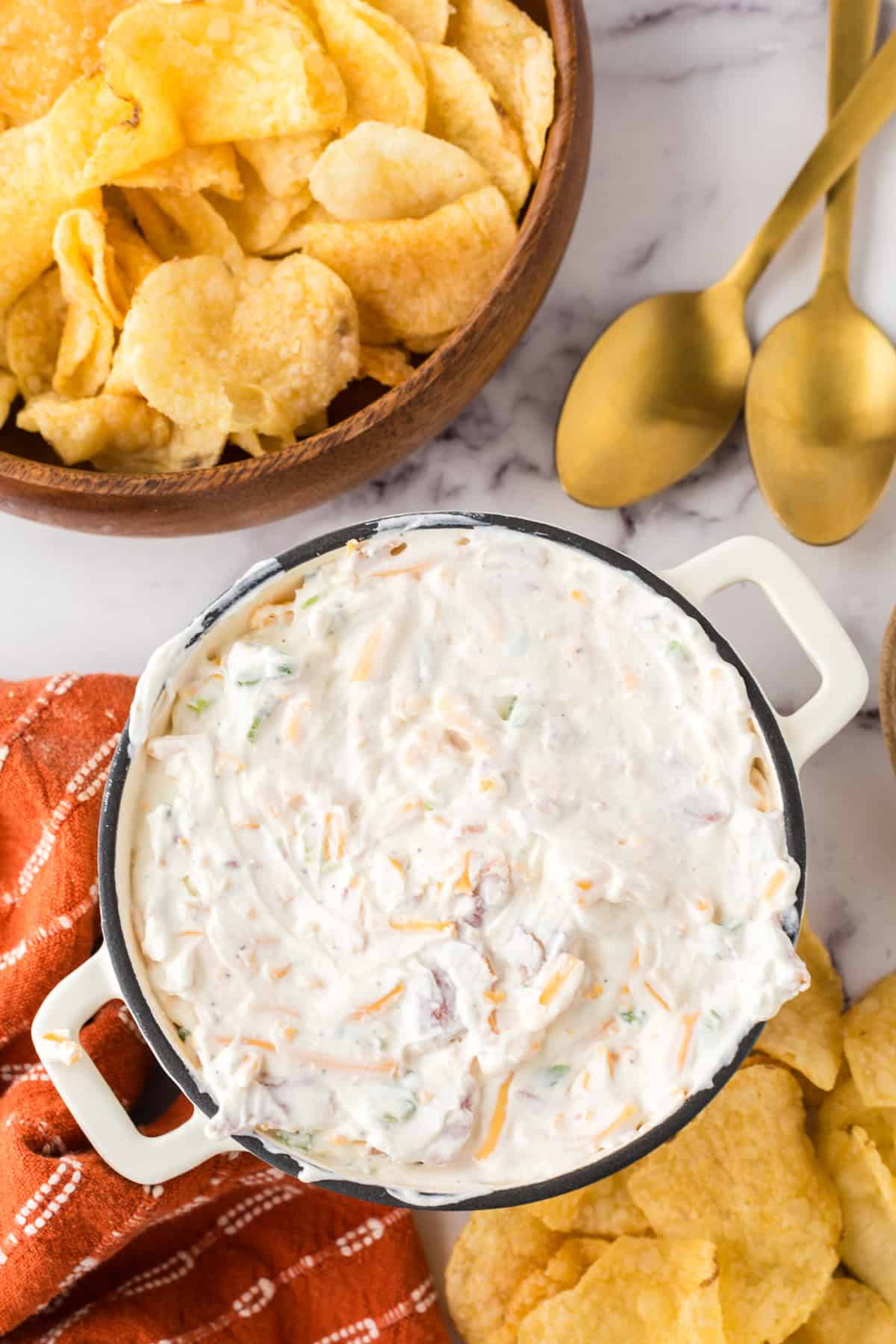 loaded baked potato dip in a bowl with potato chips.