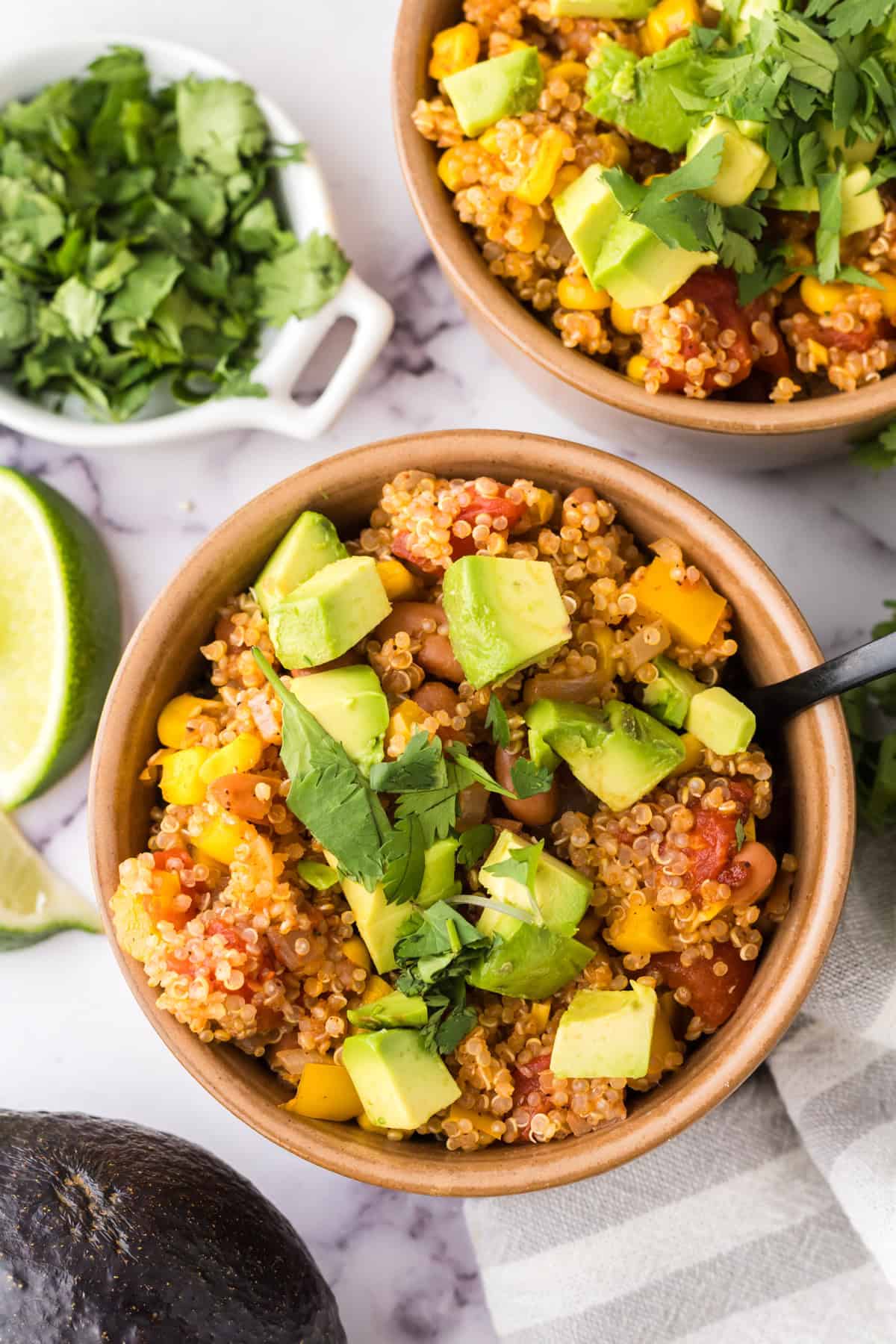 bowls with one pot quinoa taco casserole recipe with avocado and cilantro on top.