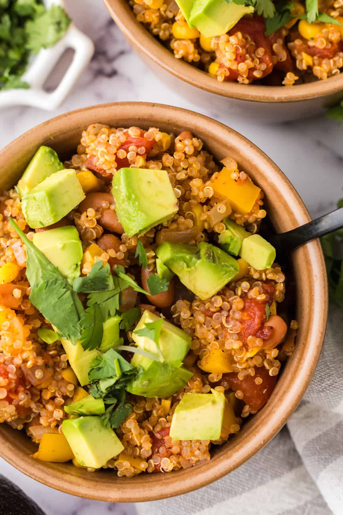 bowls with one pot quinoa taco casserole recipe with avocado and cilantro on top.