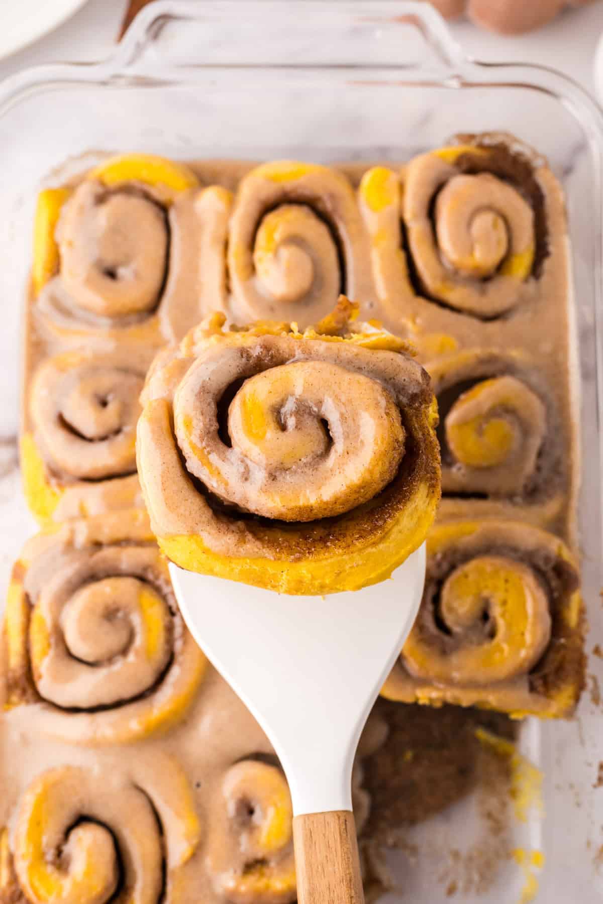 pumpkin cinnamon roll recipe on a spatula.