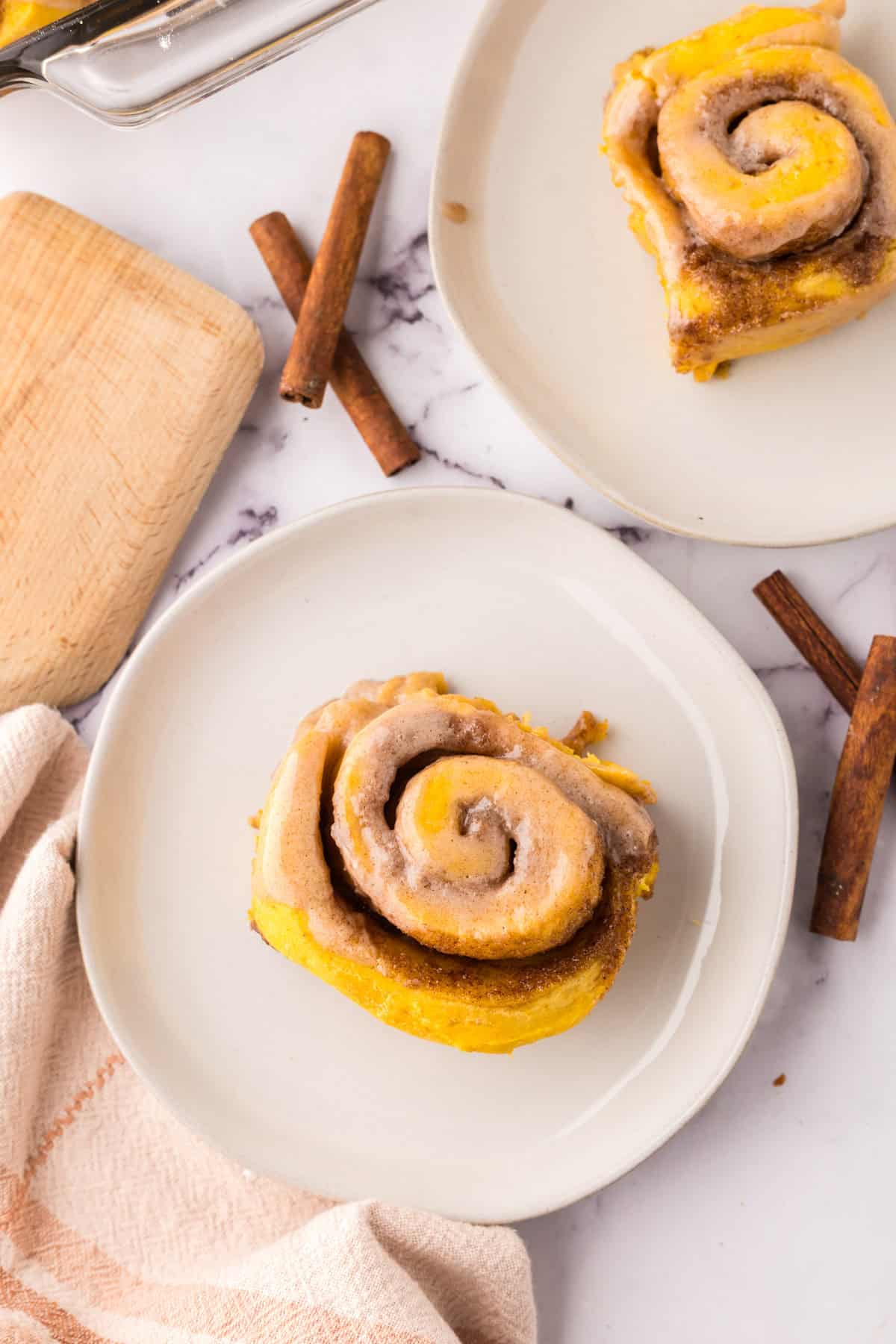 pumpkin cinnamon roll recipe on a round white plate.