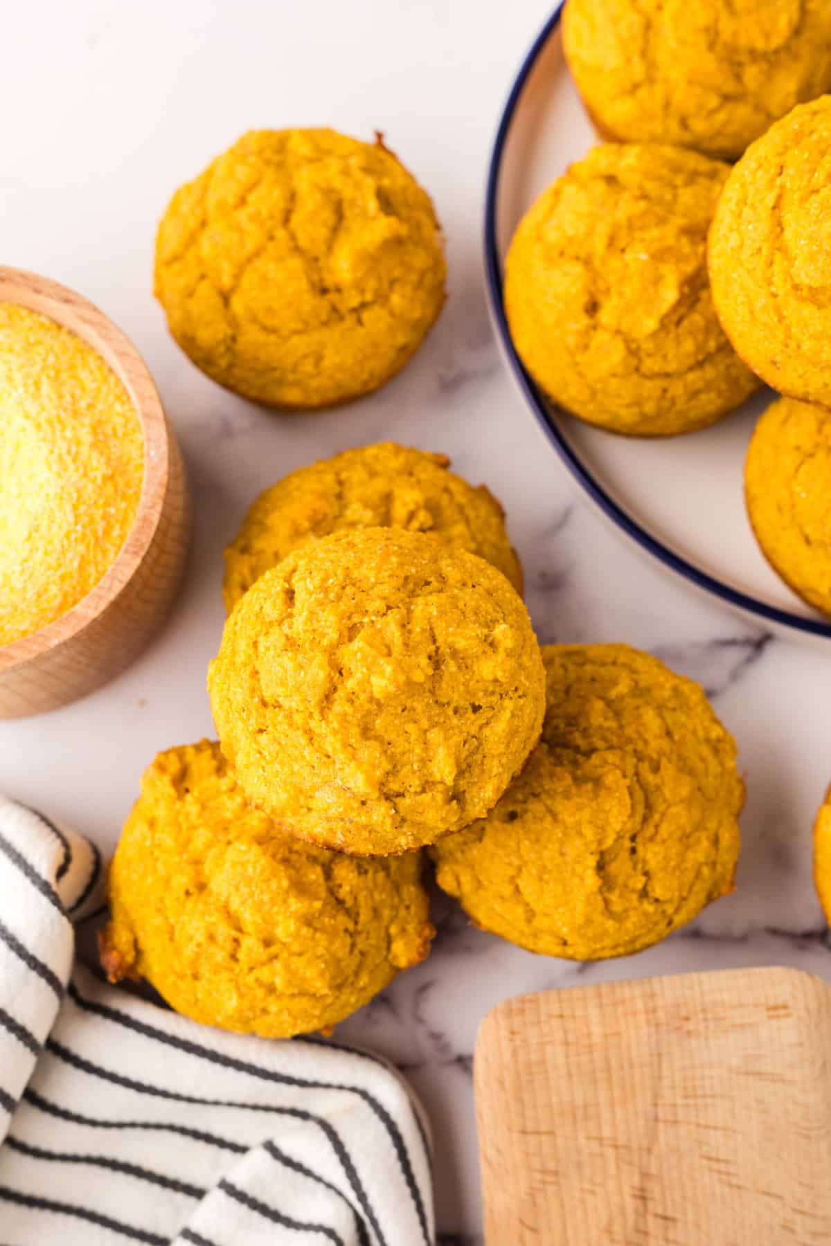pumpkin cornbread muffins stacked around a round plate.