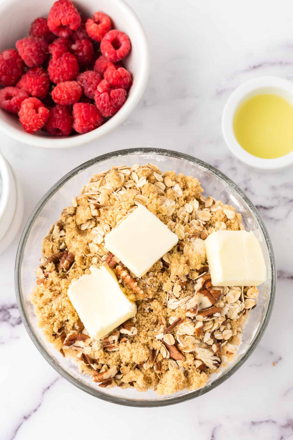 clear mixing bowl in the process of making raspberry streusel bars.