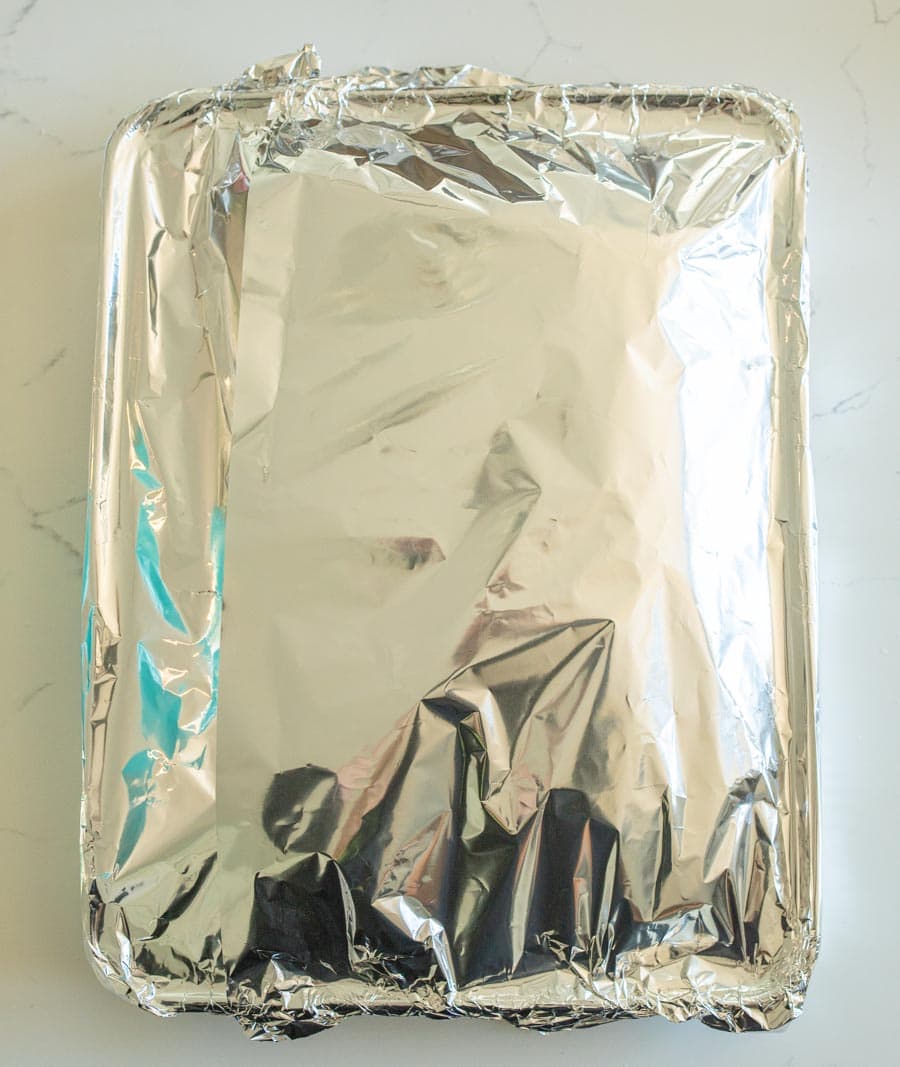 Roasted chicken thighs and potatoes covered with foil.