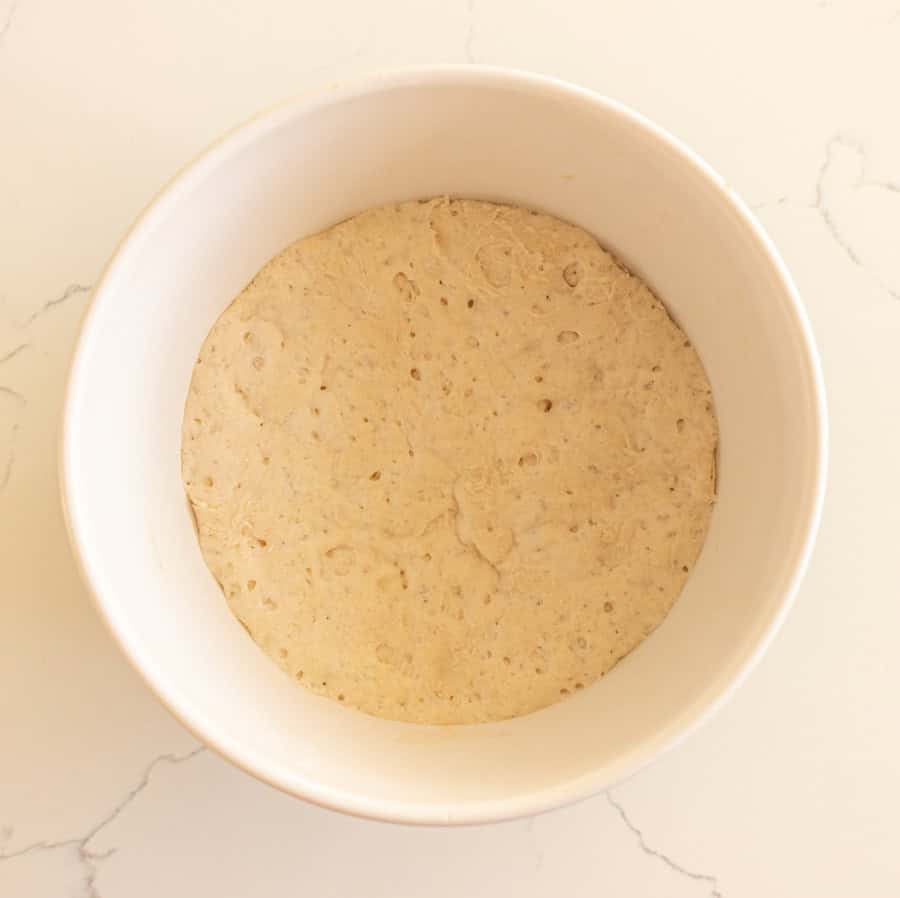 A white bowl with the sponge of water, flour and yeast for making homemade Italian bread.