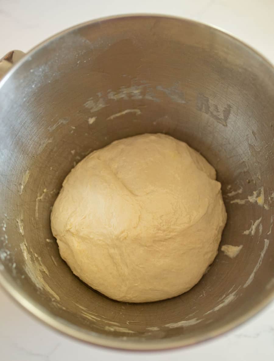 The Italian bread dough in a ball in a lightly oiled bowl.