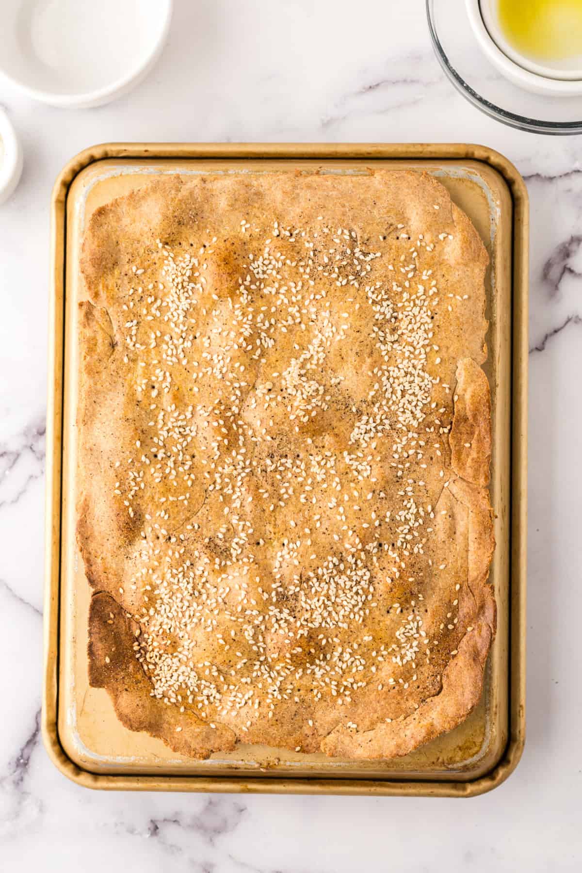 lavish bread crackers on a baking sheet.