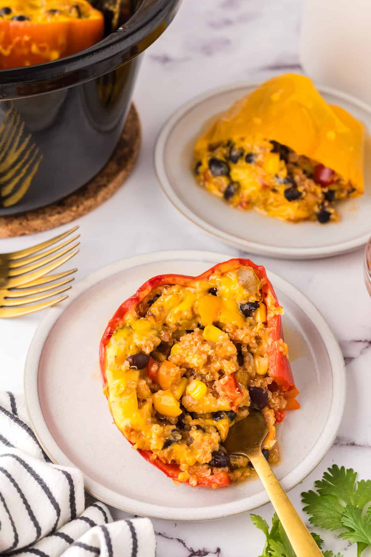 one slow cooked stuffed bell pepper on a round white plate with a fork.
