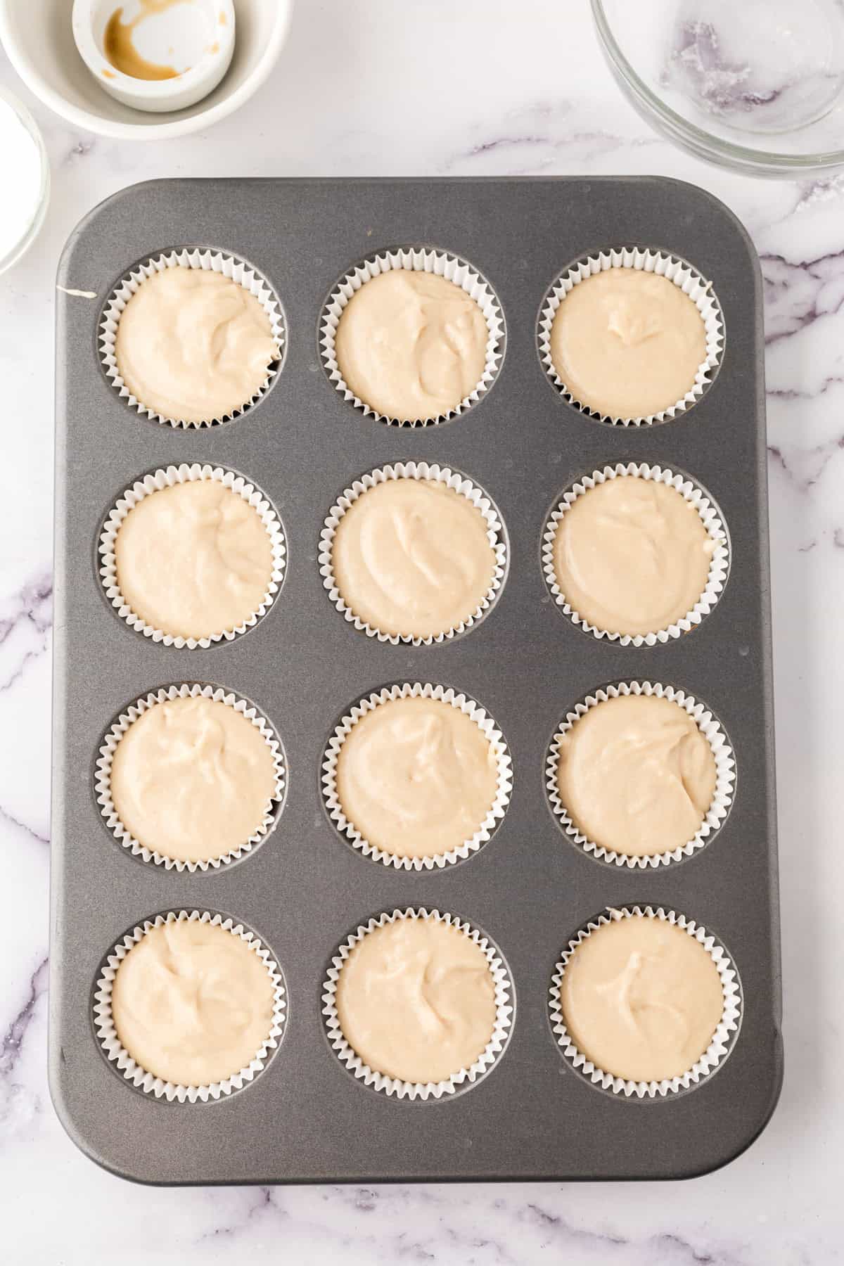 vanilla cupcake batter in a cupcake tin.