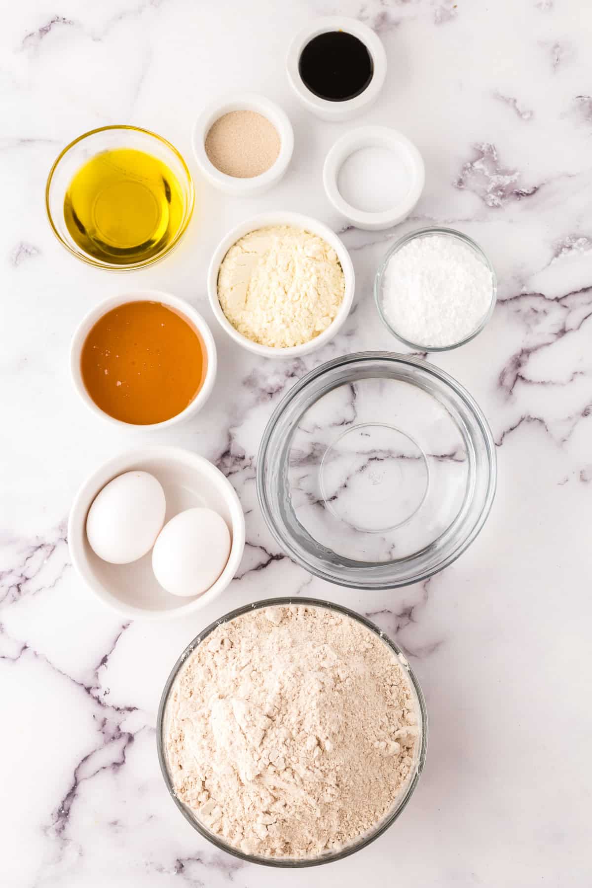 portion bowls each with raw ingredients to make wheat bread recipe.