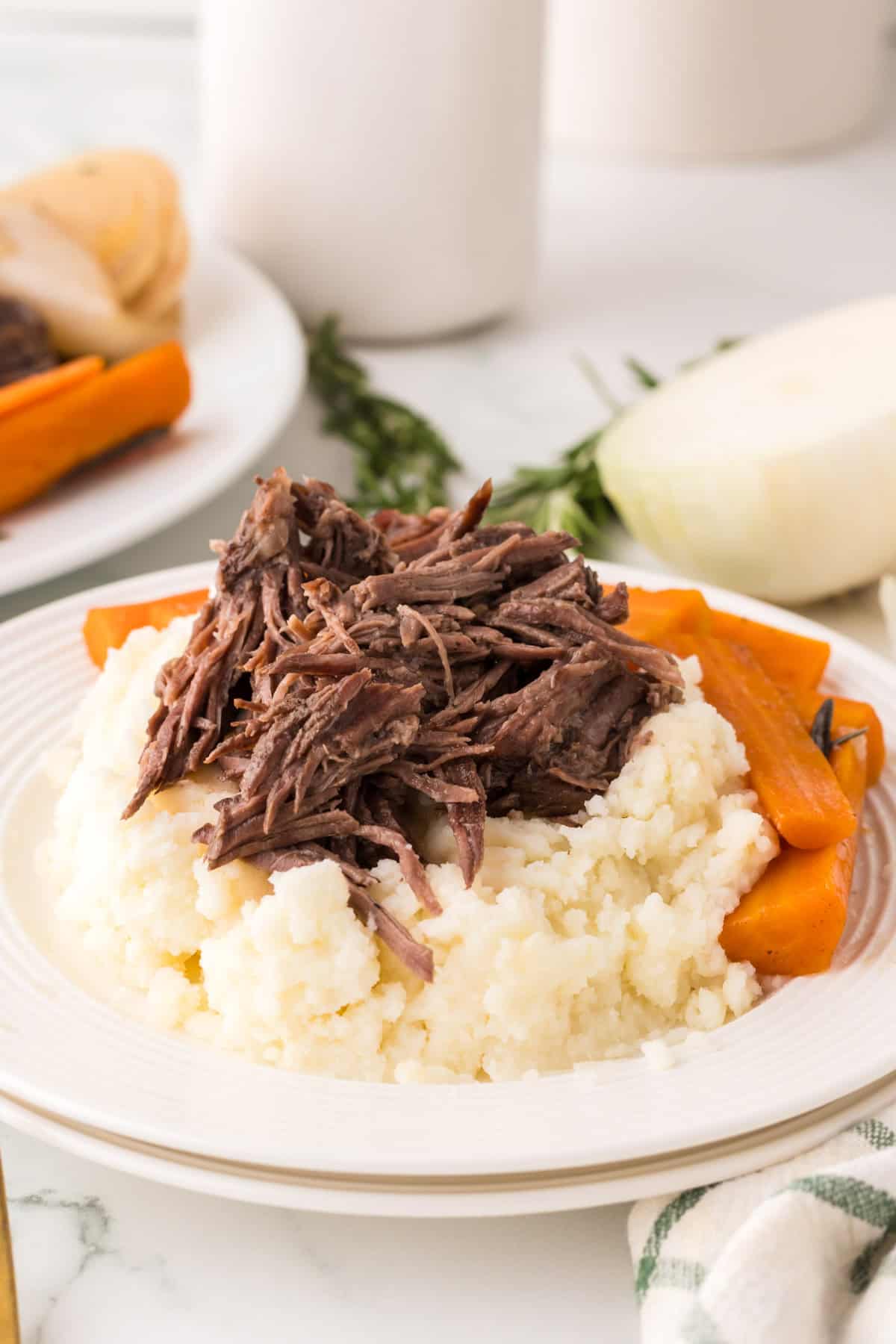 slow cooker pot roast dinner on a round white plate.