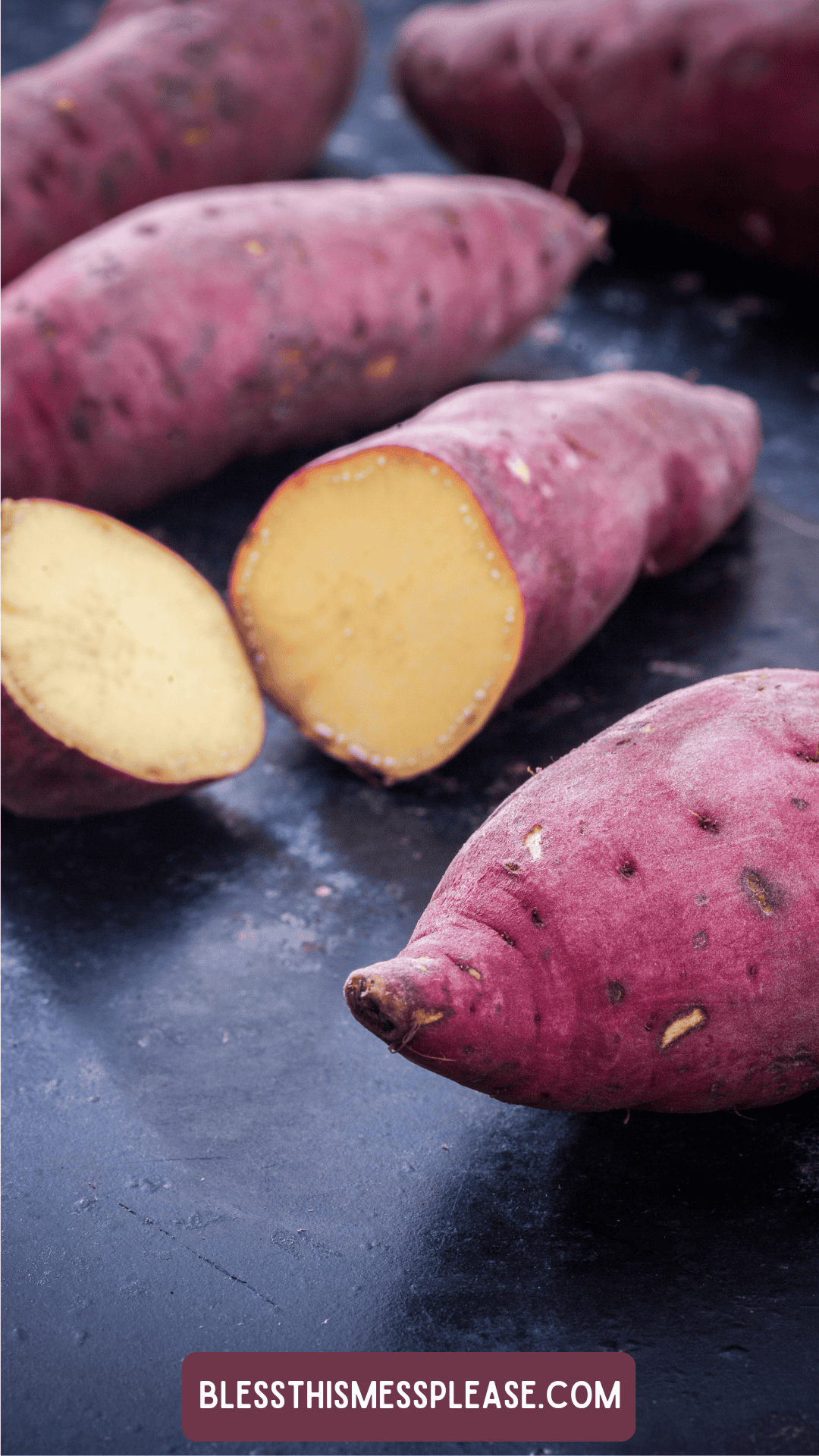 Whole and halved raw sweet potatoes with reddish-purple skins and pale yellow flesh rest on a dark surface. Curious about how to preserve sweet potatoes? Find tips at the label: