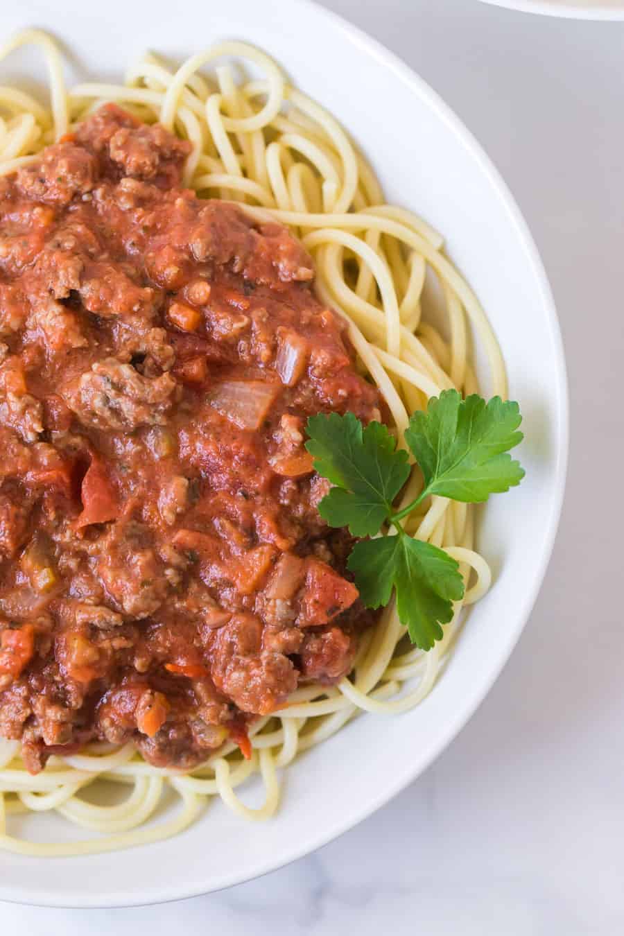 A bowl of spaghetti with sauce and parsley—perfect for those looking to plan meals on a budget without sacrificing flavor.