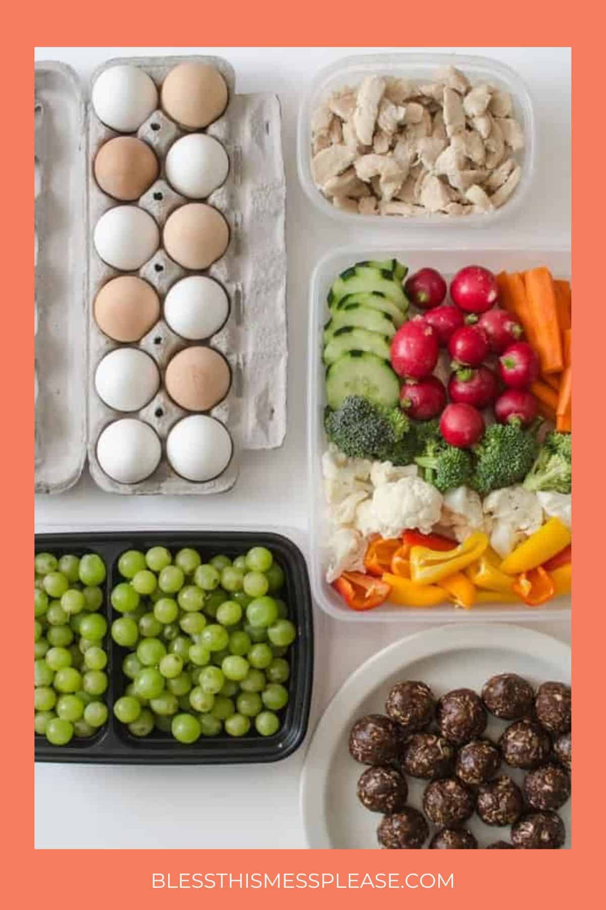 A variety of healthy foods are arranged on a table, including eggs, cooked chicken strips, sliced vegetables, grapes, and round chocolate snack balls. The image has an orange border and the website at the bottom.